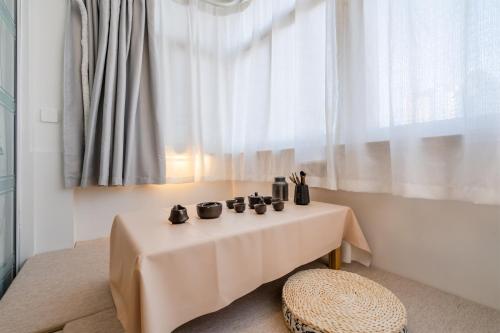 a table with four cups on it in front of a window at Mermaid's Secret-Bontique Homestay in Qingdao