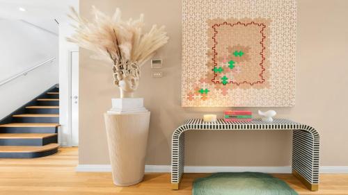 ein Wohnzimmer mit einem Tisch und einem Gemälde an der Wand in der Unterkunft The Lake House - The Vintage in Pokolbin