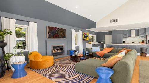 ein Wohnzimmer mit zwei Sofas und einem Kamin in der Unterkunft The Lake House - The Vintage in Pokolbin