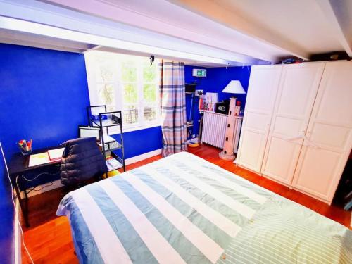 une chambre avec des murs bleus et un grand lit dans l'établissement Beautiful quiet family loft Paris, à Paris
