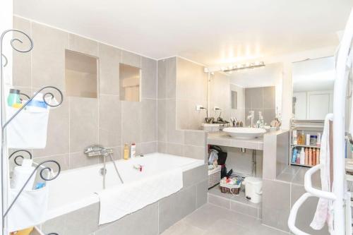une salle de bain avec un lavabo et une baignoire dans l'établissement Beautiful quiet family loft Paris, à Paris