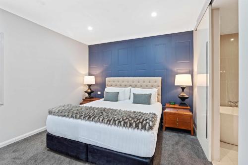 a bedroom with a large bed and a blue wall at de Russie Boutique Hotel in Orange