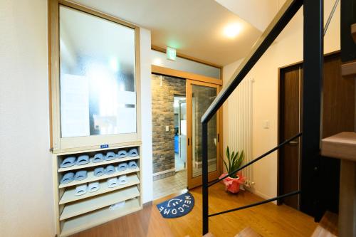 a room with a large window and a staircase at Crea House in Sapporo