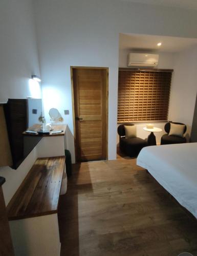 a hotel room with a bed and a living room at 小時公館城西 in Yuli