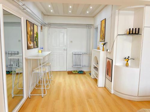 a room with white walls and a hardwood floor at Mermaid's Secret-Bontique Homestay in Qingdao