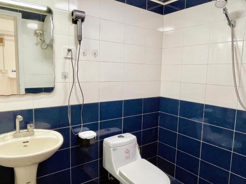 a blue and white bathroom with a toilet and a sink at Mermaid's Secret-Bontique Homestay in Qingdao