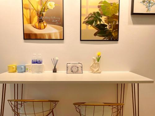 a table with two chairs and pictures on the wall at Mermaid's Secret-Bontique Homestay in Qingdao