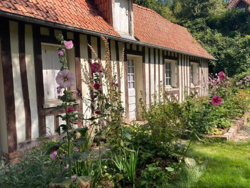 un jardin devant une maison avec des fleurs dans l'établissement Le Clos de l'Église, à Longueil