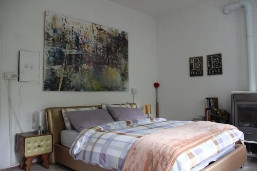 a bedroom with a bed and a painting on the wall at Dolomiti house in Cibiana