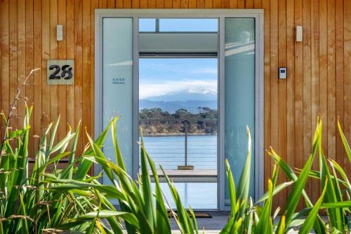 a glass door with a view of a mountain at Sunset Bay Escape in Alonnah