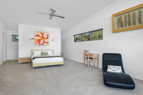 a bedroom with a bed and a chair in it at Sunset Bay Escape in Alonnah