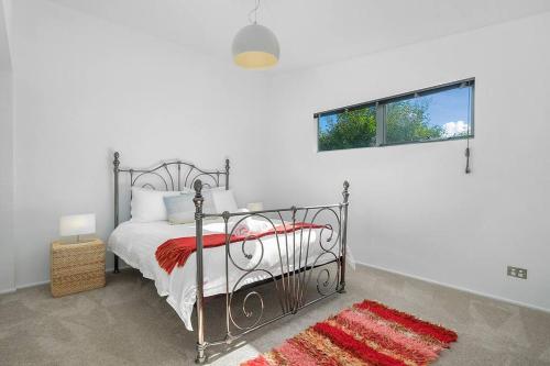 una camera da letto con un letto di metallo con un tappeto rosso di Sunset Bay Escape ad Alonnah