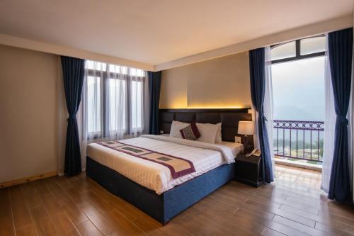 サパにあるBora Hotelの大きなベッドと大きな窓のある寝室