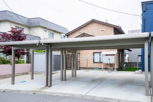 a covered parking lot in front of a house at Taro's House Midori in Aomori