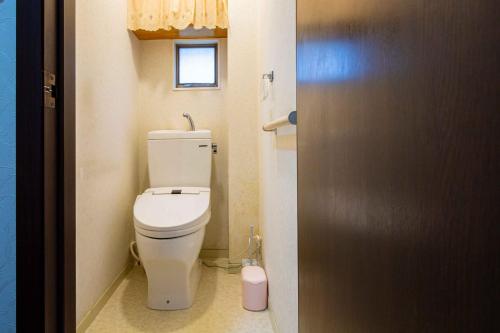 a bathroom with a toilet and a window at Taro's House Midori in Aomori