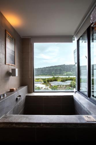 a large bath tub in a bathroom with a large window at Chii Lih Resort in Luye