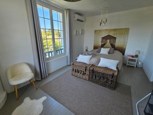 une chambre avec un lit, une chaise et une fenêtre dans l'établissement VILLA ARKIA 4 étoiles - family friendly, à Anglet