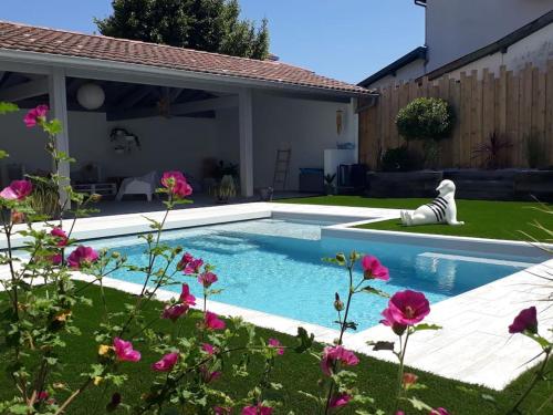 - une piscine dans une cour ornée de fleurs roses dans l'établissement VILLA ARKIA 4 étoiles - family friendly, à Anglet