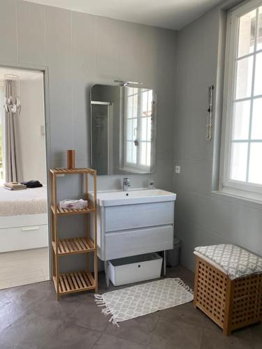 une salle de bain blanche avec un lavabo et un miroir dans l'établissement VILLA ARKIA 4 étoiles - family friendly, à Anglet