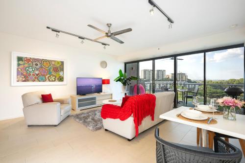 a living room with a couch and a tv at Darwin Waterfront Luxury Suites in Darwin