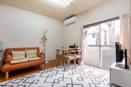 a living room with a couch and a table at Golden House in Tokyo