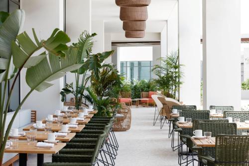 a restaurant with tables and chairs and plants at Hotel Indigo Grand Cayman by IHG in Grand Cayman
