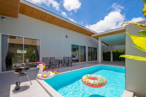 a swimming pool in a house with a swan float at Sasi Pool Villa Phuket in Rawai Beach