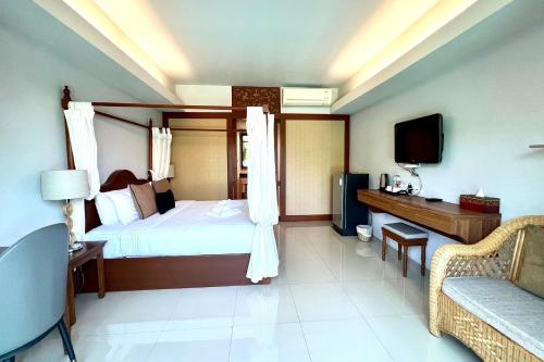 a bedroom with a bed and a tv and a couch at Phuhunsa Boutique Hotel in Nan