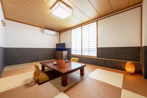 a living room with a table and a window at Okano Hotel in Sendai