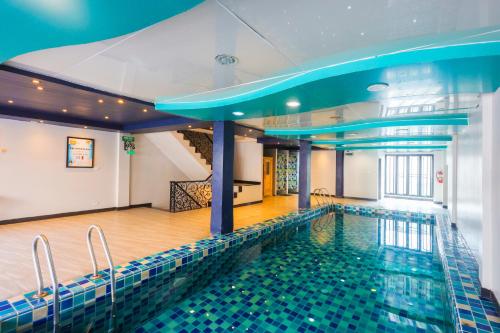 a pool in a building with a swimming pool at Land Royal Residence Pattaya in Pattaya South