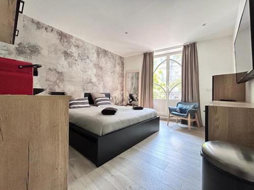 a bedroom with a bed and a chair in it at Maison hyper centre maxi 24pers Tour d'Auvergne in Clermont-Ferrand