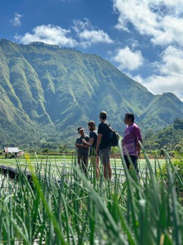 a group of people standing in front of a mountain at Rautani Sembalun in Sembalun Lawang
