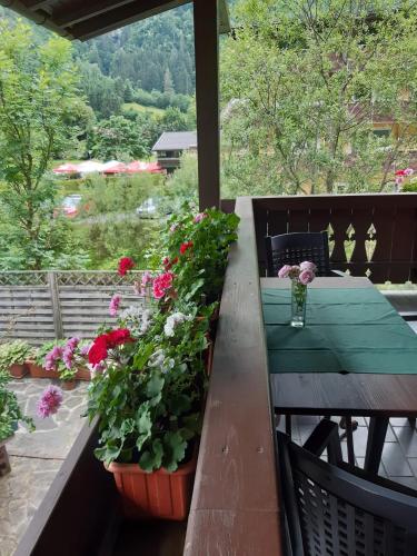 a table with flowers and a vase on a balcony at Ella's in Fusch an der Glocknerstraße