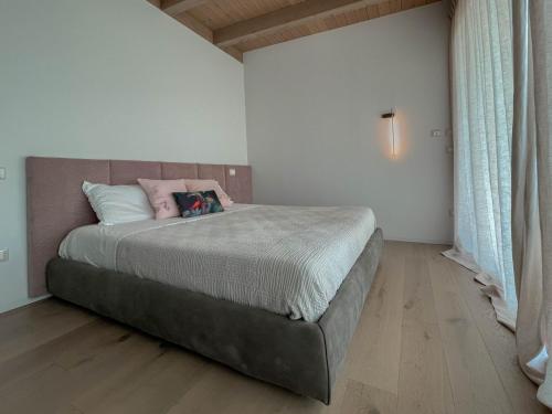 a bedroom with a bed with a pink pillow on it at Villa Pirello in Guardiagrele