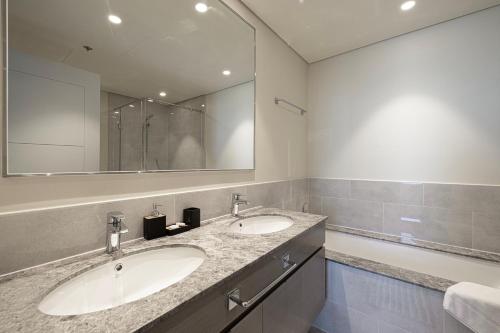 a bathroom with two sinks and a large mirror at Luxury 4BR Burj Khalifa & Fountain Views in Dubai