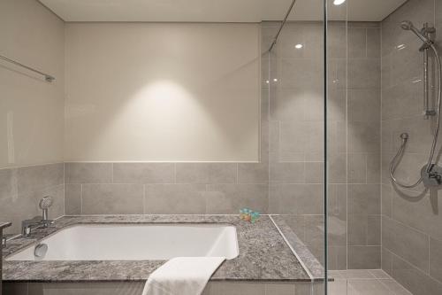a bathroom with a bath tub and a shower at Luxury 4BR Burj Khalifa & Fountain Views in Dubai