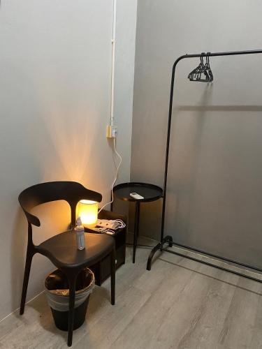 a room with a chair and a table and a lamp at Aayu Muntri - 4 mins to Chulia St George Town in George Town