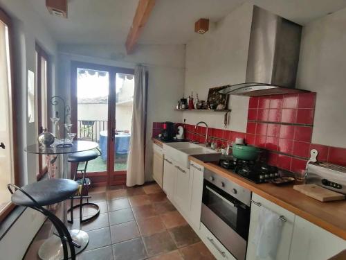 une cuisine avec un évier et une cuisinière four supérieur dans l'établissement Belle chambre dans maison de charme, à Caunes-Minervois