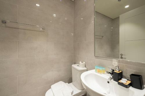a bathroom with a toilet and a sink and a mirror at Luxury 4BR Burj Khalifa & Fountain Views in Dubai