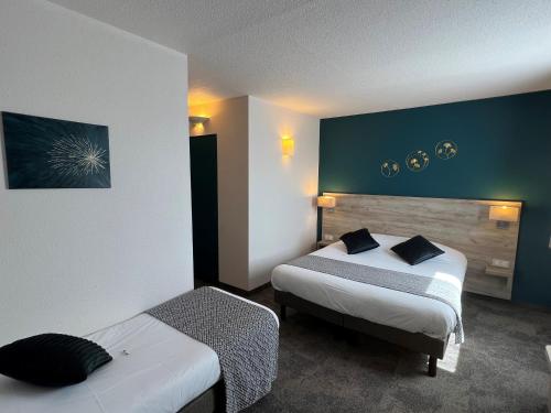 a hotel room with two beds in a room at Brit Hotel Saumur in Distré