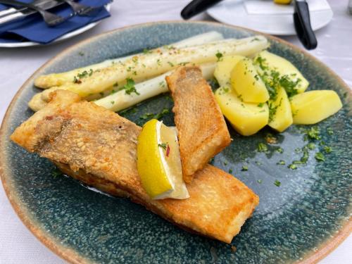 a plate of food with fish and vegetables on it at Hotel Luther Birke Wittenberg in Lutherstadt Wittenberg