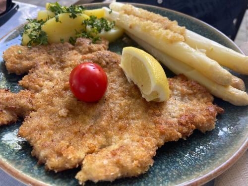 a plate of food with a piece of chicken and vegetables at Hotel Luther Birke Wittenberg in Lutherstadt Wittenberg