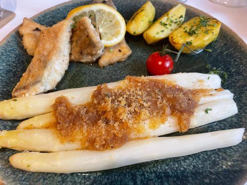 a plate of food with fish and other foods at Hotel Luther Birke Wittenberg in Lutherstadt Wittenberg