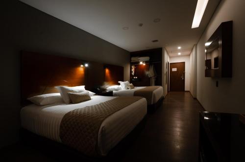 a hotel room with two beds and a hallway at Hotel Mitru Sur in La Paz
