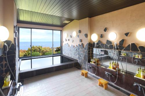 a bathroom with a shower and a large window at SADO二ツ亀ビューホテル in Sado