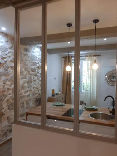 un miroir reflétant une cuisine avec un évier et une pièce dans l'établissement Coup de cœur pour amoureux en vadrouille, au Muy