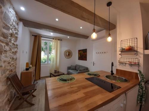une cuisine et un salon avec une table et un canapé dans l'établissement Coup de cœur pour amoureux en vadrouille, au Muy