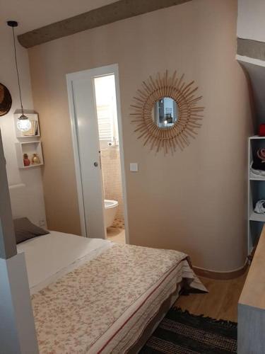 une chambre avec un lit et un miroir au mur dans l'établissement Coup de cœur pour amoureux en vadrouille, au Muy
