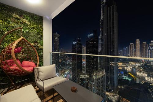 a balcony with a view of a city at night at Luxury 4BR Burj Khalifa & Fountain Views in Dubai