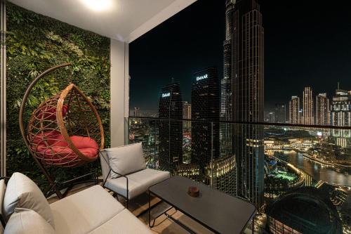 a room with a view of a city at night at Luxury 4BR Burj Khalifa & Fountain Views in Dubai
